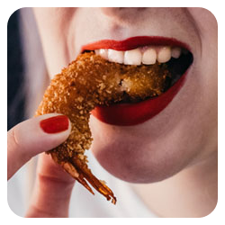 photo d'une personne qui mange une crevette dans un restaurant