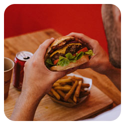 photo d'une personne qui tient un burger dans ses mains dans un restaurant